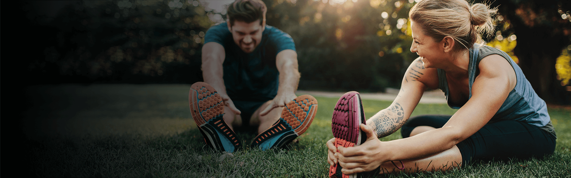 woman and man stretching on grass